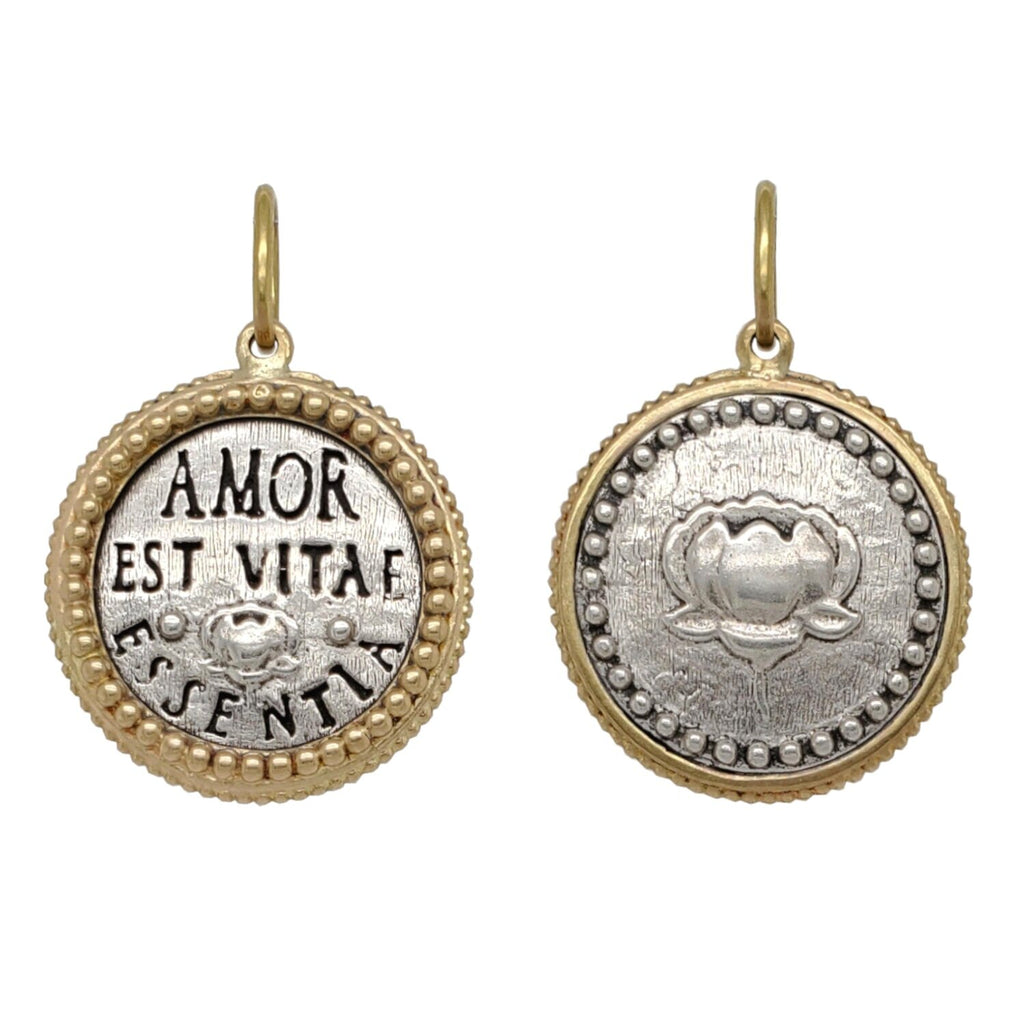 double lotus  charm shown in oxidized sterling silver with 18k gold rim & bail  reads "love is the essence of life" #c153c