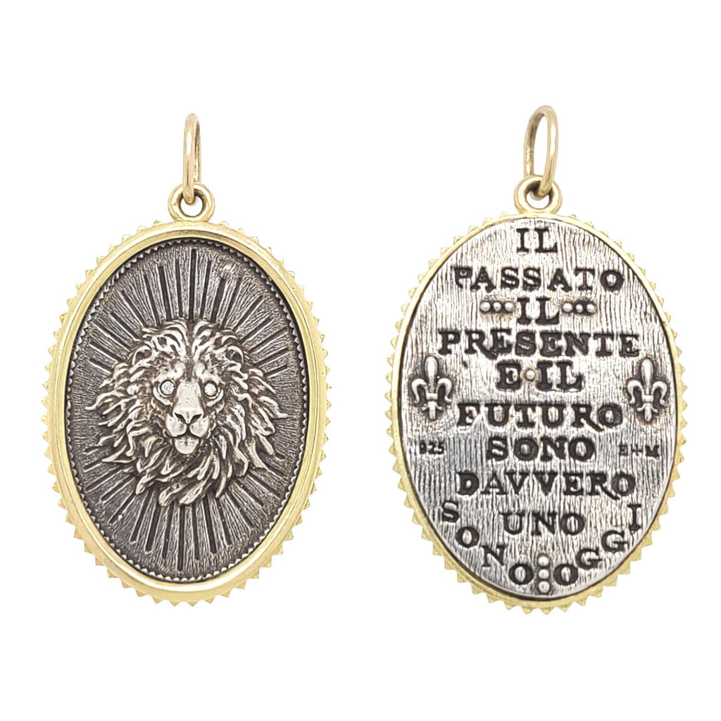 large oval lion head double sided charm with  white diamond .01cts eyes reads "The past, present & future are all truly one" by Harriet Beecher Stowe. Shown in oxidized sterling silver with 18k gold rim & bail #c354d